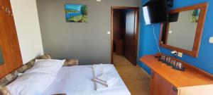 a bedroom with a bed and a dresser with a mirror at GRAND - Beachfront Rooms & Apartments in Selce