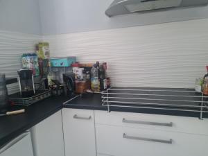 a kitchen with white cabinets and a black counter top at Petite maison du samedi au samedi in Biscarrosse