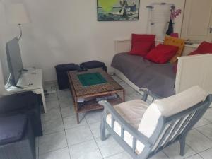 a living room with a bed and a table and a chair at Petite maison du samedi au samedi in Biscarrosse