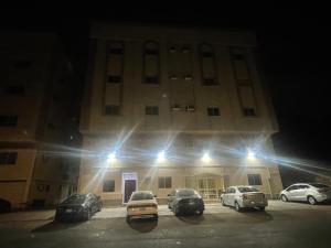 メディナにあるشقق الفتح الخاصة Al Fath Private Apartmentsの夜間に駐車場に車が駐車されている建物