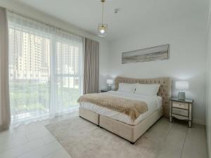 a bedroom with a bed and a large window at Jumeirah Beach Residences Private Beach & Sea View in Dubai