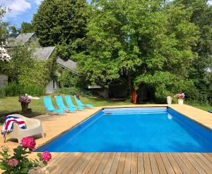 a swimming pool with chairs and a deck with a house at Cottage house Lublin in Lublin
