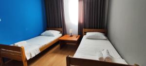 two beds in a room with a blue wall at GRAND - Beachfront Rooms & Apartments in Selce