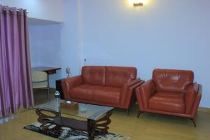 two leather chairs and a coffee table in a living room at Best Southern Hotel in Kuākāta