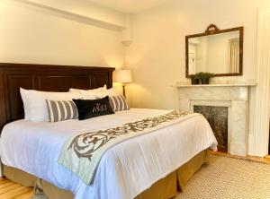 Un dormitorio con una cama y una chimenea. en Old Village Inn Ogunquit, en Ogunquit 4 fotos más