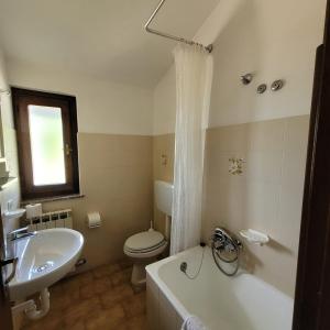 a bathroom with a tub and a toilet and a sink at Sette Colli Mountain Lake Iseo Hospitality in Bossico