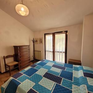 a bedroom with a blue and white quilt on a bed at Sette Colli Mountain Lake Iseo Hospitality in Bossico +5 photos