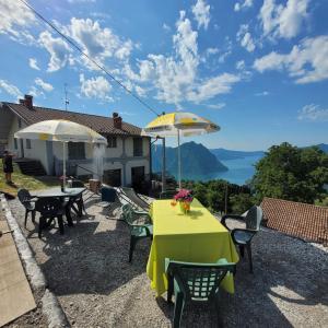 a patio with a table and chairs and umbrellas at Sette Colli Mountain Lake Iseo Hospitality in Bossico