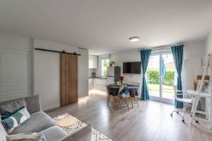 a living room with a couch and a table and a kitchen at Un havre de paix in Thonon-les-Bains