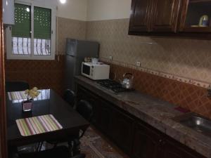 a kitchen with a counter with a microwave and a stove at Appartement à louer UNIQUEMENT pour famille et couple marié in Mohammedia