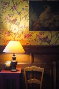 a lamp on a table in a room with a painting at La Maison Saint Aignan in Saint-Aignan