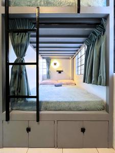 ein Schlafzimmer mit einem Etagenbett in einem Zimmer in der Unterkunft A Casa Portuguesa Coron Boutique Hostel in Coron