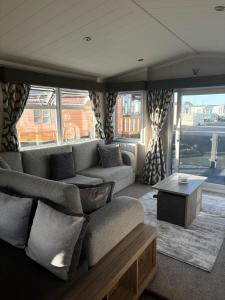 a living room with a couch and a table at The Retreat Sea Breeze - Golden Sands Holiday Park in Kinmel Bay