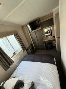 a bedroom with a bed in a small room at The Retreat Sea Breeze - Golden Sands Holiday Park in Kinmel Bay