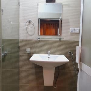 a bathroom with a sink and a shower with a mirror at The Empire Inn in Ratnapura +6 photos