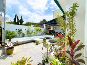 eine Außenterrasse mit Pflanzen, einem Tisch und Stühlen in der Unterkunft A Casa Portuguesa Coron Boutique Hostel in Coron