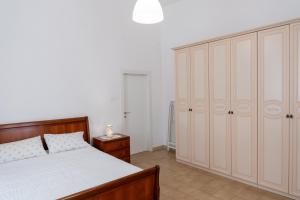 马泰拉La Lanterna Del Sasso的一间卧室配有床和白色的大橱柜