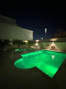 a swimming pool lit up at night at Quiet Zoon in Jeddah