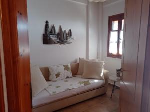 un divano in soggiorno con finestra di Euphoria Living Holiday Home a Pouríon