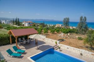 uma villa com piscina e vista para o oceano em Savvas Villa em Argaka