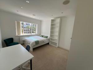 a bedroom with a bed and a window at 4 to 5 Bedroom beautiful holiday home London sleeps 9-central Links in London