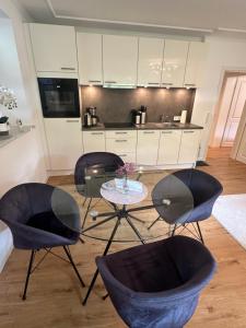 a kitchen with three chairs and a table with a table at Sandy Coast Apartment Souterrain in Timmendorfer Strand +9 photos