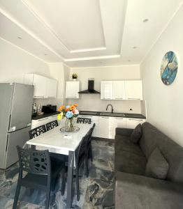 カターニアにあるNaomi Luxury Home 2のキッチンとテーブルとソファのあるリビングルーム