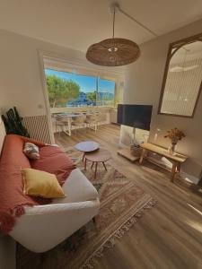 a living room with a couch and a large window at Appartement de Standing vue port in La Baule