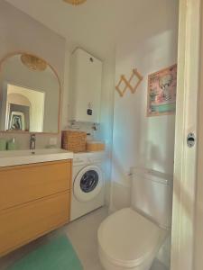 a bathroom with a toilet and a sink and a washing machine at Appartement de Standing vue port in La Baule +4 photos