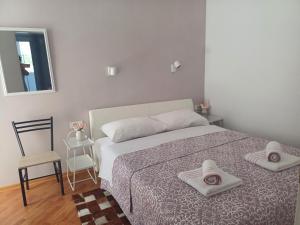 a bedroom with a bed with two towels on it at Loni in Klenovica