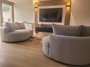 a living room with two chairs and a tv at Llanesmar in Posada de Llanes