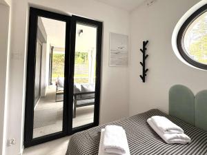 a bedroom with a mirror and a bed and a chair at CASA DEL MAR Apartamenty przy plaży in Pobierowo +10 photos