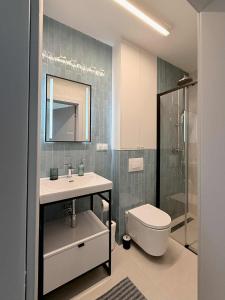 a bathroom with a sink and a toilet and a mirror at CASA DEL MAR Apartamenty przy plaży in Pobierowo