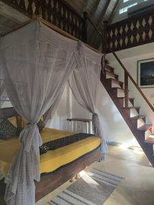 a bedroom with a canopy bed with a staircase at SURF N SUN - Arugam Bay in Arugam Bay