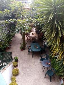 a patio with tables and chairs in a garden at Metro Casa Música Apartments and Rooms in Porto