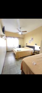 a hotel room with two beds and a ceiling fan at Excelsior in San Bernardo +9 photos