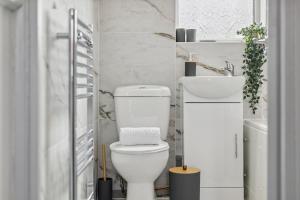 a bathroom with a white toilet and a sink at Large 5Bed House London Next CUH Free Parking in Mitcham Junction +40 photos