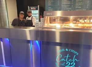two people standing behind a counter in a bakery at The Retreat Sea Breeze - Golden Sands Holiday Park in Kinmel Bay +37 photos