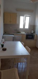 a kitchen with a white table and chairs at Thaleia Studios & Apartments in Kavos