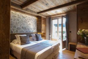a bedroom with a bed and a large window at Au Coin Du Feu in Megève +79 photos