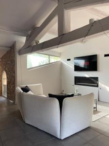 un salon avec un canapé blanc et une table dans l'établissement La Tuilerie du Bazalac, à La Celle-sous-Gouzon