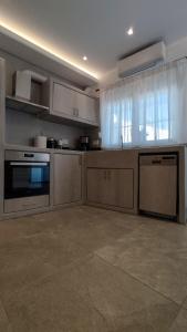 a large kitchen with a stove and a dishwasher at Marina's House in Kinídharos