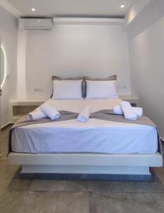 a bed with white pillows and a blue frame at Marina's House in Kinídharos