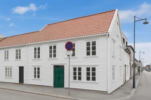 a white building with a red roof on a street at Renovated 2025 - AC & terrace - Historic building in Kristiansand