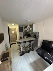 a kitchen and living room with a table and a couch at Résidence les Mélèzets 2 au pieds des pistes et des commerces in Modane