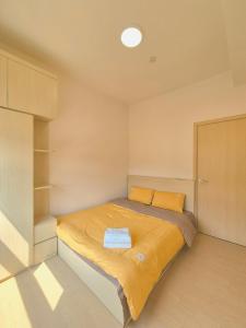 una piccola camera da letto con un letto con lenzuola gialle di Căn hộ 2 phòng ngủ 2 vệ sinh - Bãi Cháy Hạ Long Dragon Castle a Ha Long Altre 9 foto