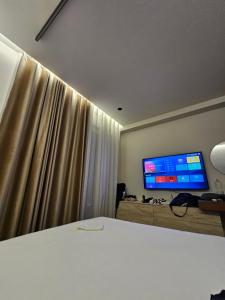 a bedroom with a bed and a television on a wall at Dejvid's Apartment in Polisi i Vogël +10 photos