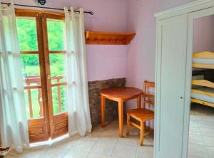 a room with a table and a chair and a window at La Borda de Ritort in Sort
