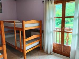 a bedroom with a bunk bed and a window at La Borda de Ritort in Sort