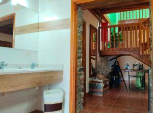 a bathroom with a sink and a wooden staircase at La Borda de Ritort in Sort